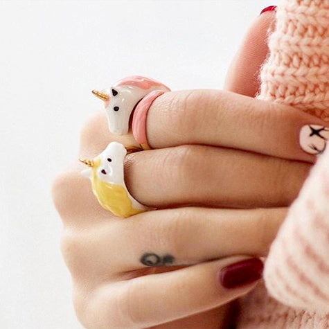Close up of two unicorn ring worn on a person's hand, perfect for unicorn lovers.
