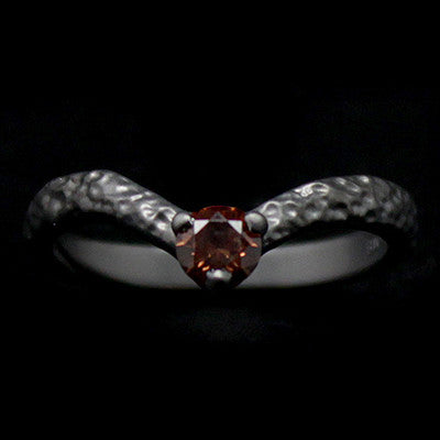 Unique textured ring design featuring a gemstone at the center.
