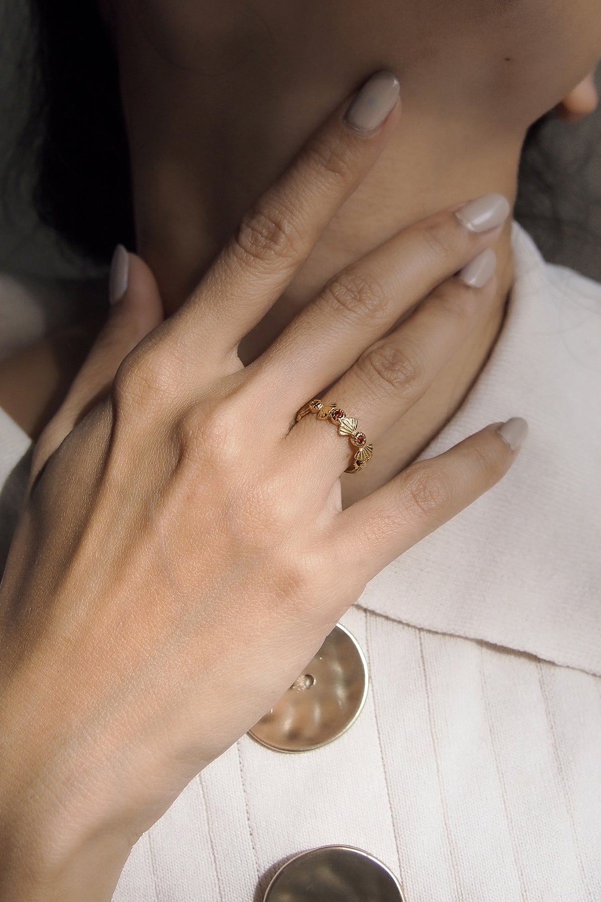 Close-up of a hand wearing a charming gold ring.