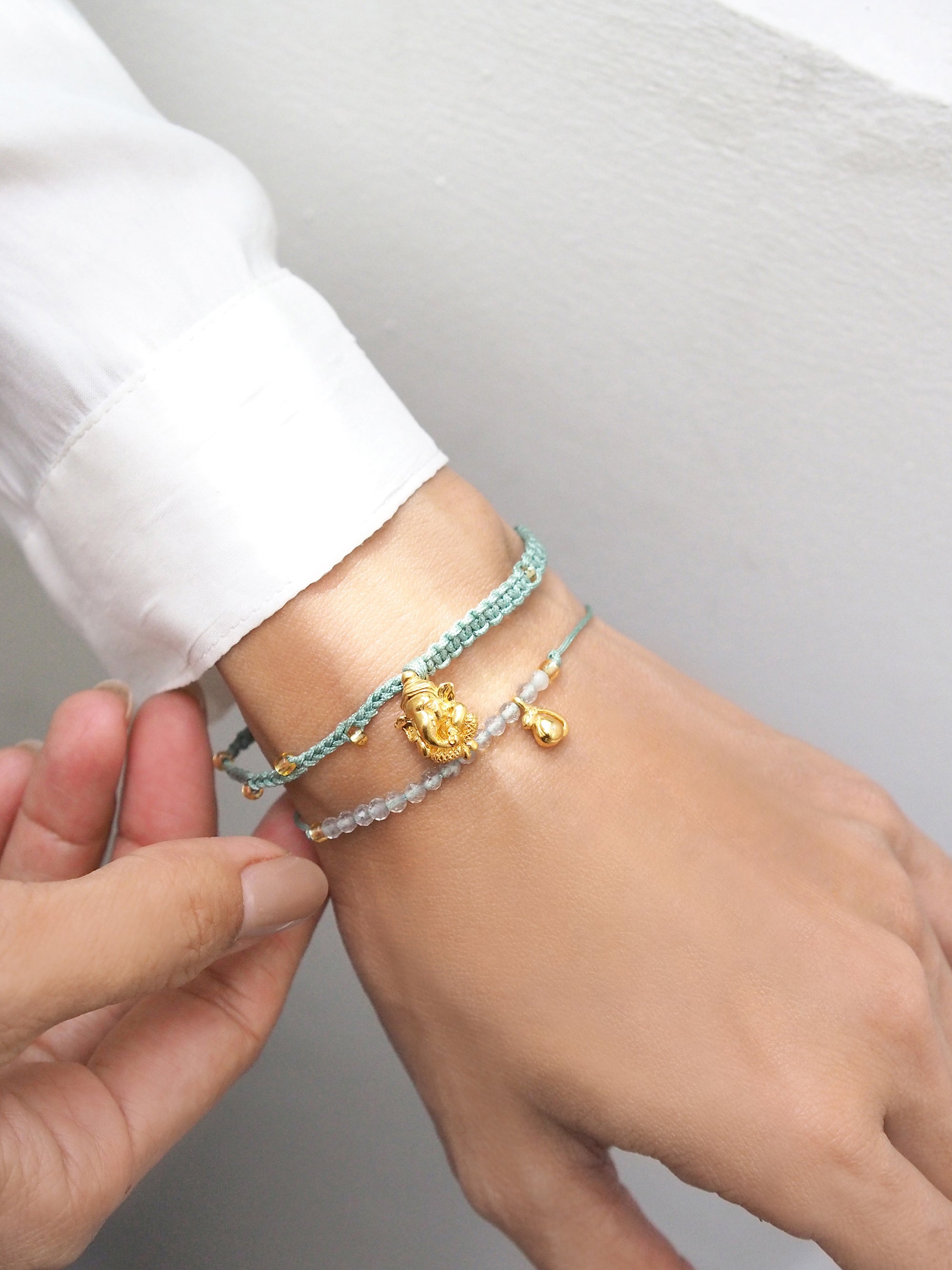 Stylish beaded Ganesh bracelet with unique charms on model's wrist.