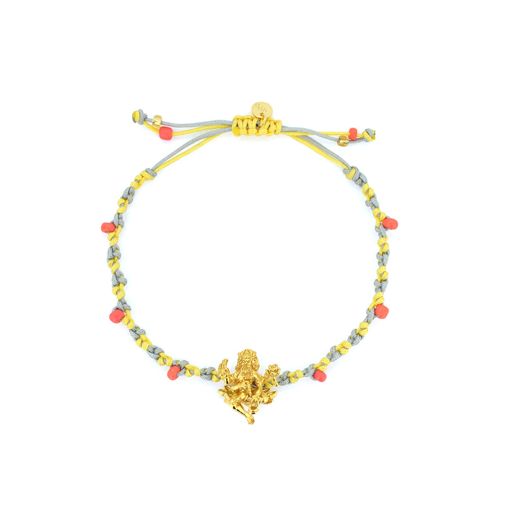 A pastel bracelet in light grey and yellow threads with pastel beads, featuring a gold Trimurti Brahma charm.