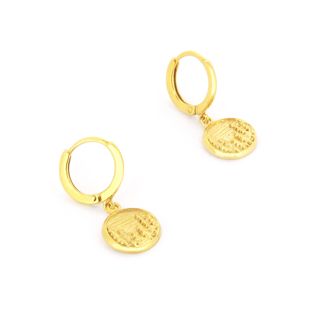 Handcrafted gold earrings with circular pendants featuring detailed forest scene, showcasing trees and a landscape.
