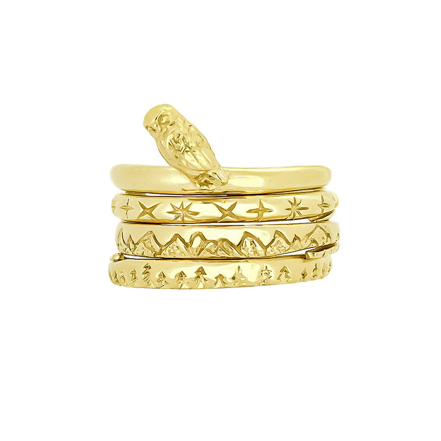 Beautifully designed gold stacking rings featuring nature-inspired designs: an owl, stars, mountains, and trees.
